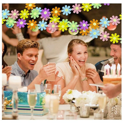 colorful felt daisy garland back drop with people celebrating together
