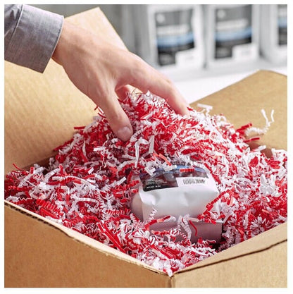 hand grabbing red and white crinkle cut shredded paper