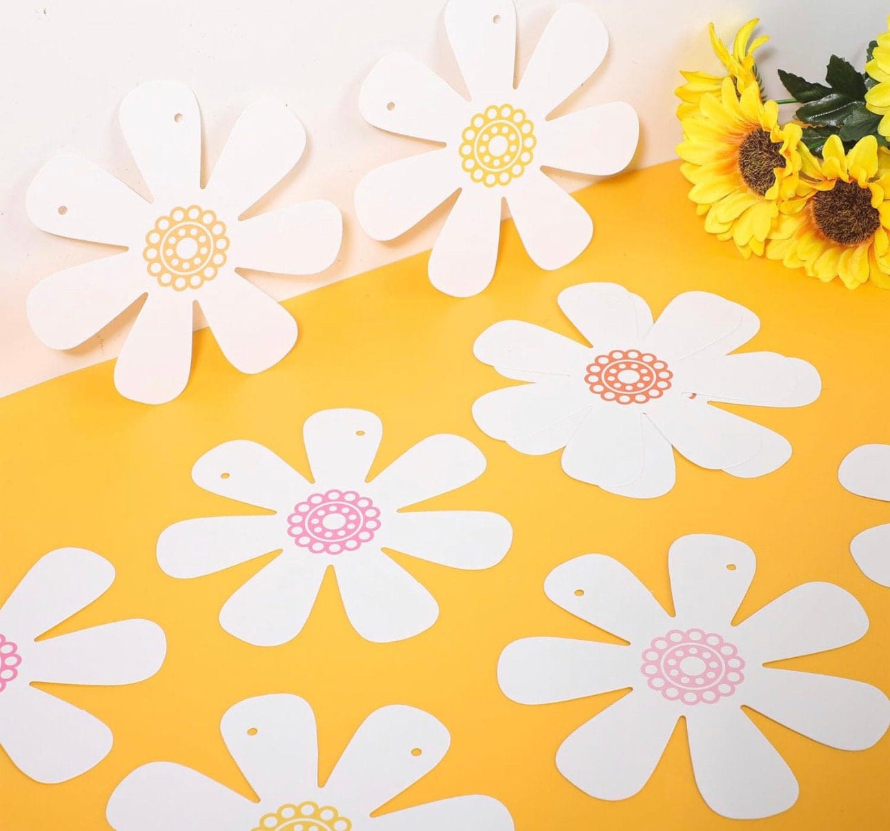 Close up of white daisy banner garland laying on a table 